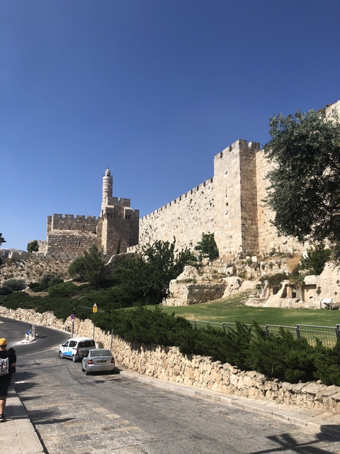 Historic stone walls and tower under a clear blue sky.