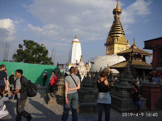       People exploring a temple complex with pagodas.
  