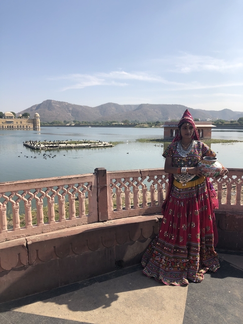 Woman in traditional Indian dress by a lake.