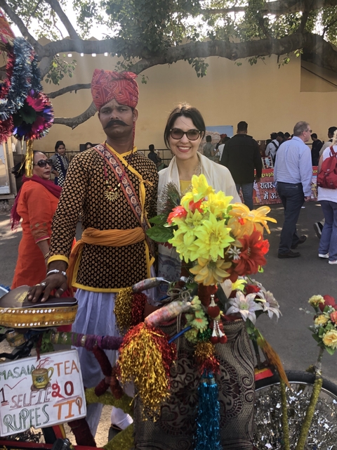       Group of people in colorful attire at a fair.
  