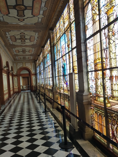 A hallway with ornate stained glass windows.