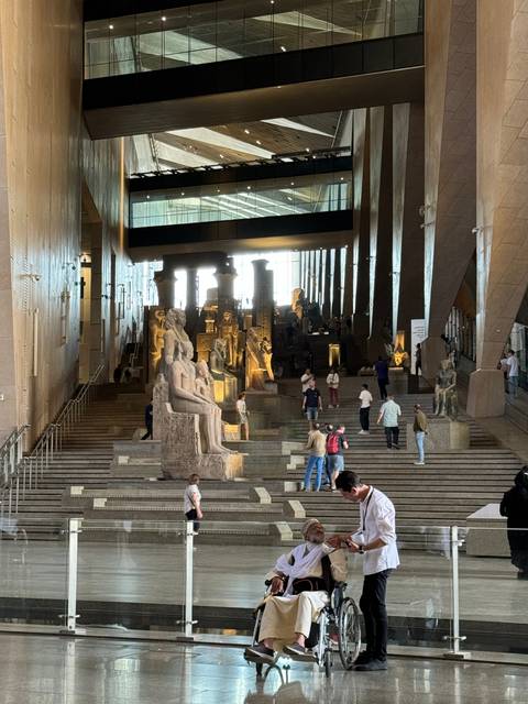       People inside a spacious museum gallery.
  
