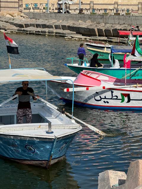       Colorful boats with people on a river.
  