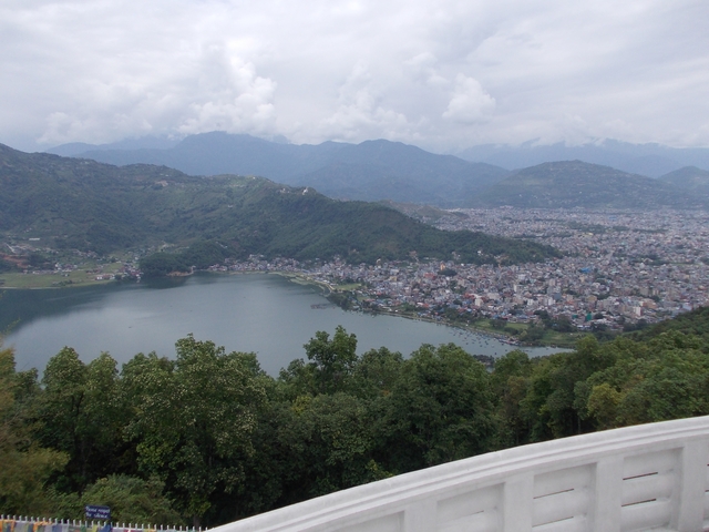 Overview of a city and lake surrounded by mountains.