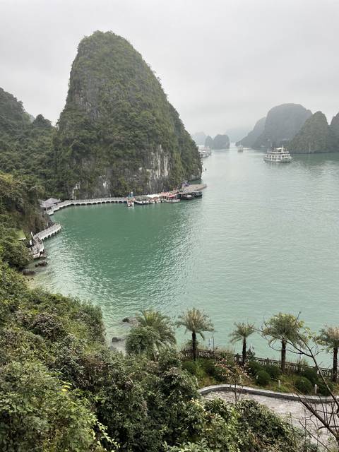       A scenic view of a coastal area with limestone mountains.
  
