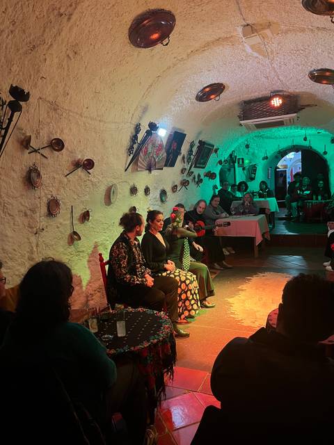 People inside a cave or enclosed space enjoying a flamenco performance.