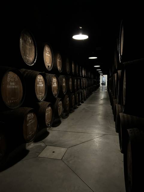Barrel storage area in a dimly lit room.