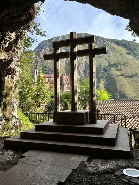       Stone cross at a mountain viewpoint.
  