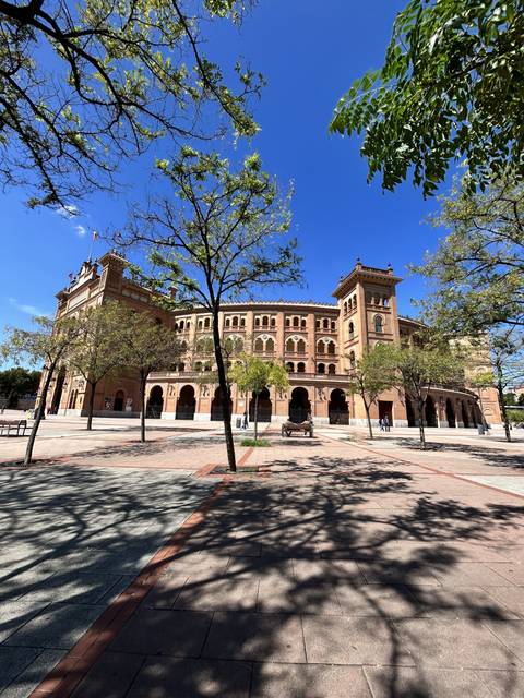 Historical building with archways and a plaza.