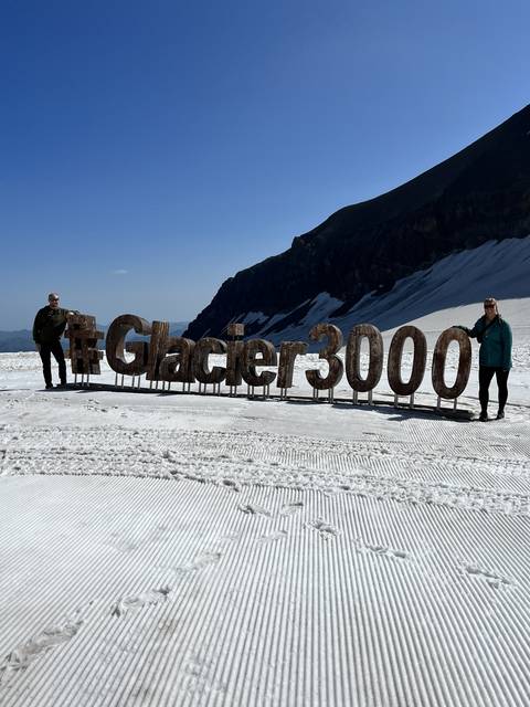       Sign reading '#Glacier3000' on a snowy mountain.
  
