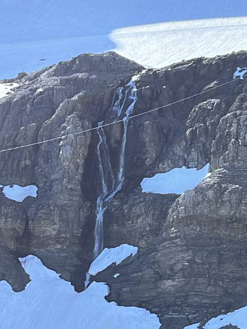       Snow-covered rocky mountains with a waterfall.
  