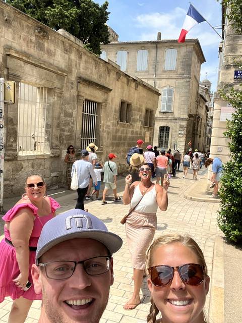       Group of people in front of historical building with a flag.
  