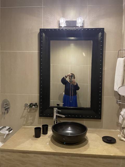       Person taking a mirror selfie in a bathroom
  