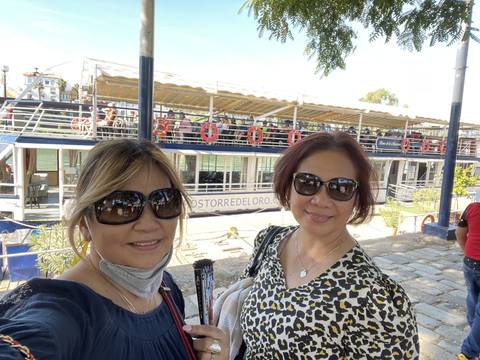 Two people taking a selfie with a restaurant backdrop