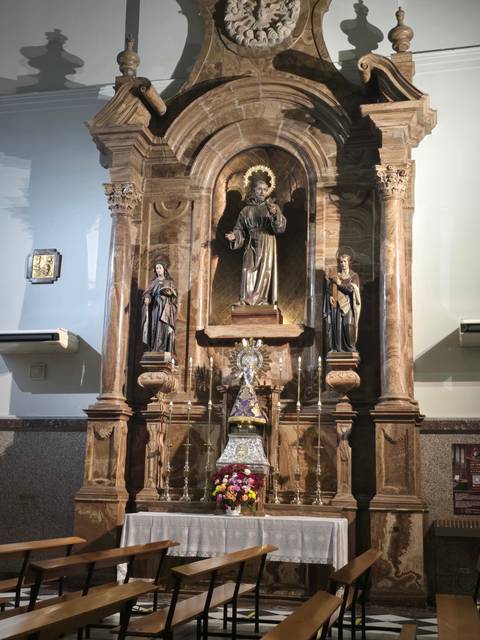       Religious altar with statues and candles.
  