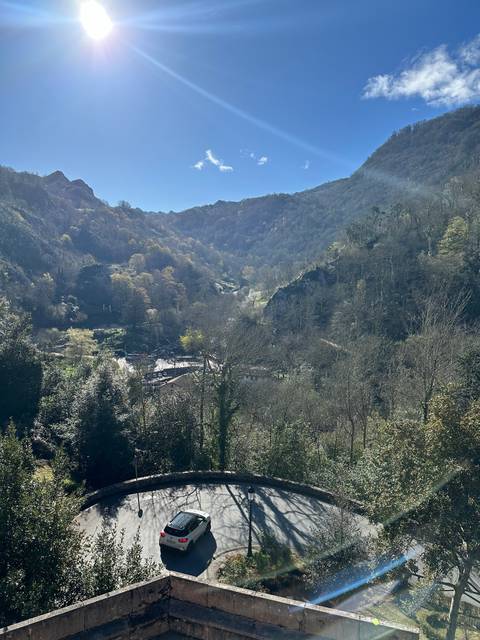 Curved road with a solitary car under bright sun.