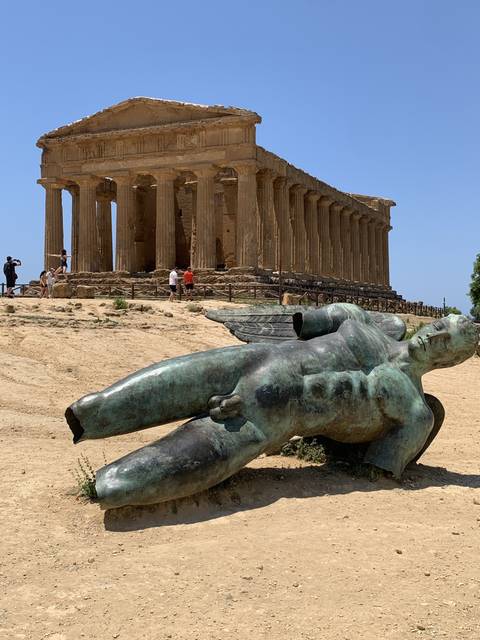       Fallen statue beside an ancient temple.
  