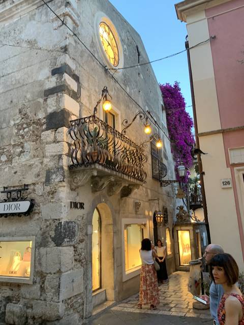       Charming street with decorated balconies and flowers.
  
