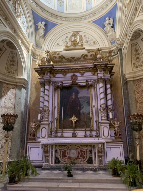       Interior altar with religious artwork in a chapel.
  