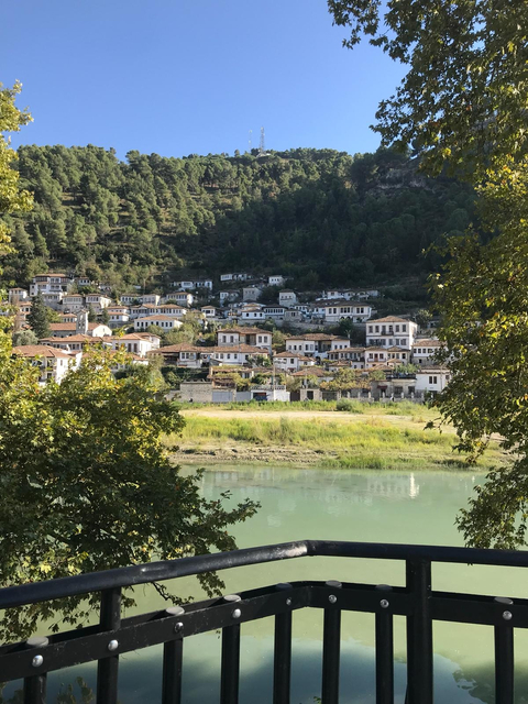Town with white houses and red roofs by the water.