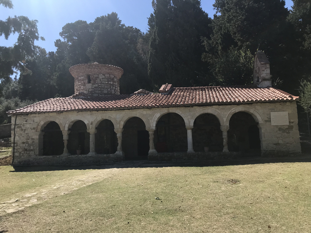 Old stone church with arches in an outdoor setting.