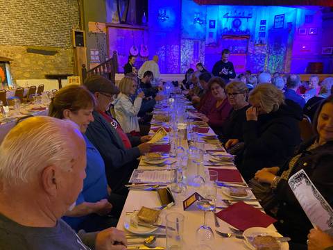 Group of people in a restaurant setting with long table