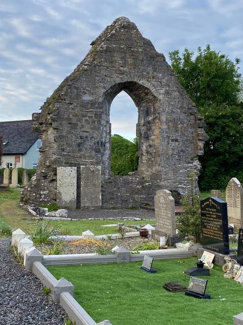 Ruined stone structure and gravestones in a cemetery