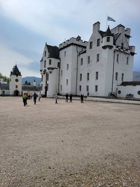 Large white building with people in the courtyard.