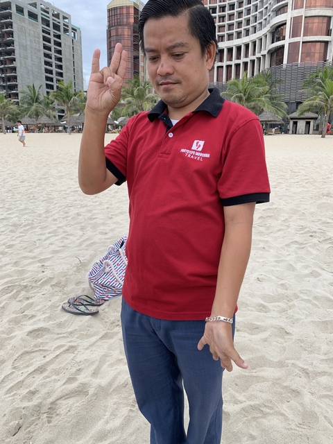 Person on a beach wearing a red polo shirt.