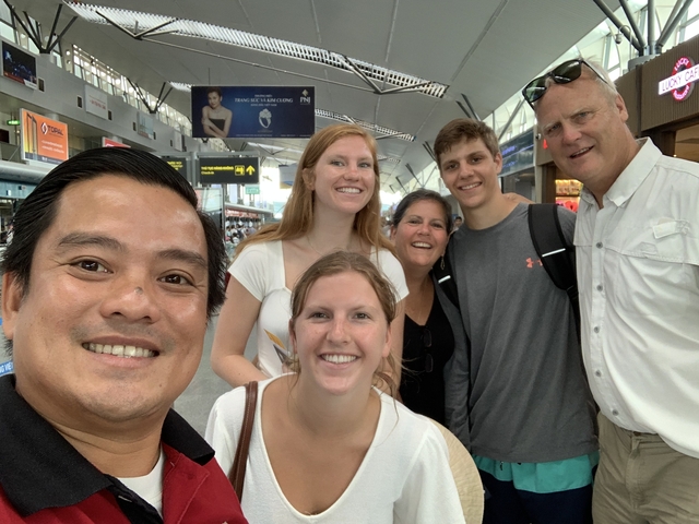 Group of people taking a selfie at an airport.
