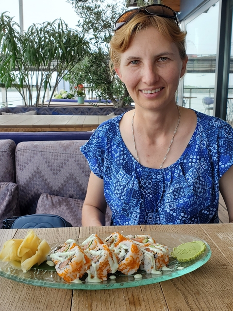       Person sitting on a couch wearing a blue patterned shirt.
  