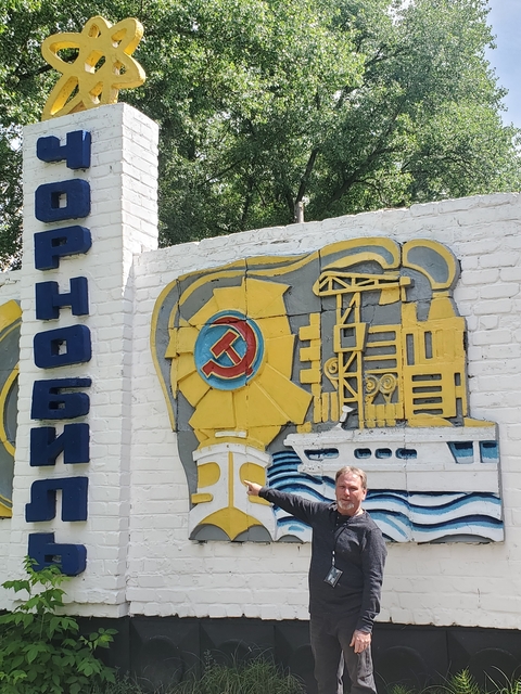 Person posing near a colorful Chernobyl sign.