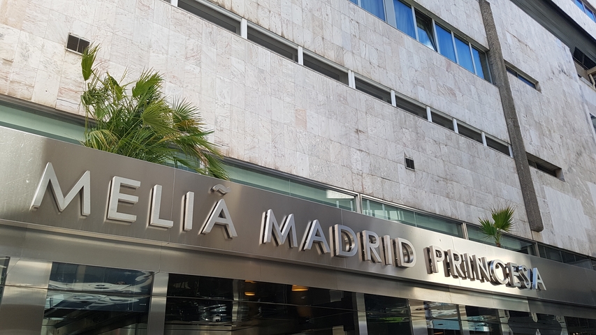       Hotel entrance with reflective sign displaying 'Meliá Madrid Princesa'.
  