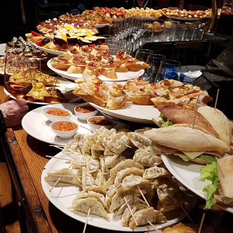      Platters of tapas and small dishes on a wooden bar.
  