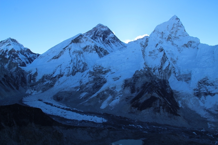 Snow-covered mountains at dawn with shadows.