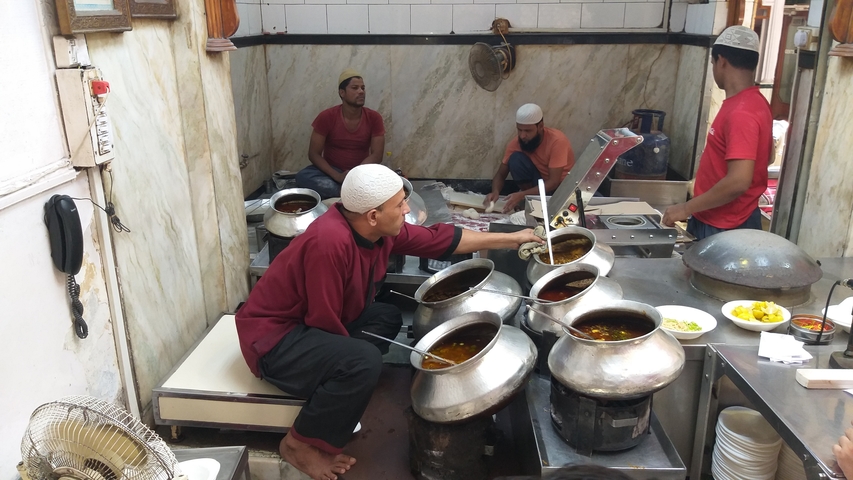       Local restaurant with chefs preparing traditional dishes
  