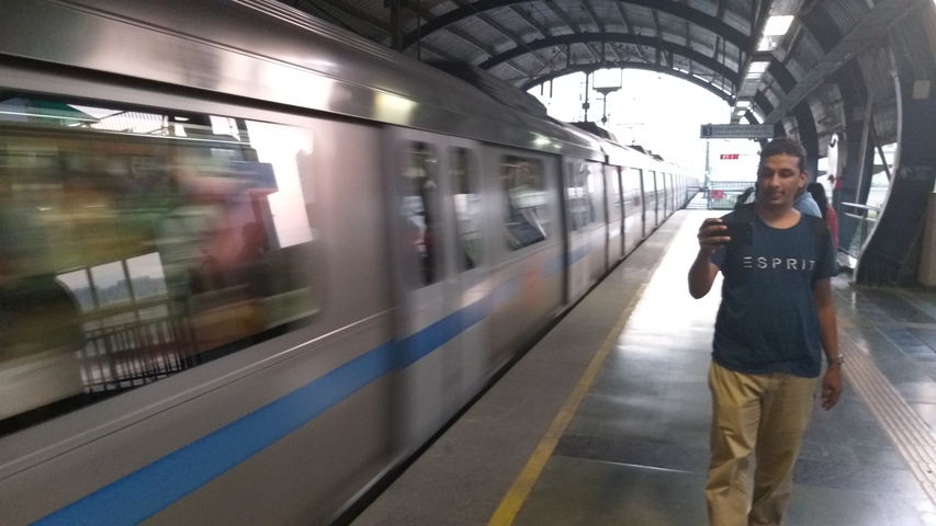       Blurred moving metro train with people on the platform
  