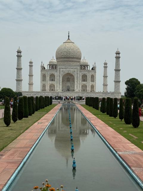 A famous white marble mausoleum reflecting in a nearby pool.