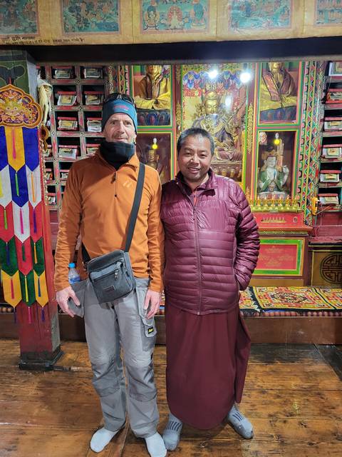 Two men indoors dressed in warm clothing.