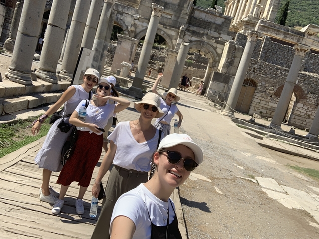 Group of tourists posing among ancient ruins.