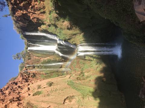       Tall cascading waterfall with lush greenery.
  