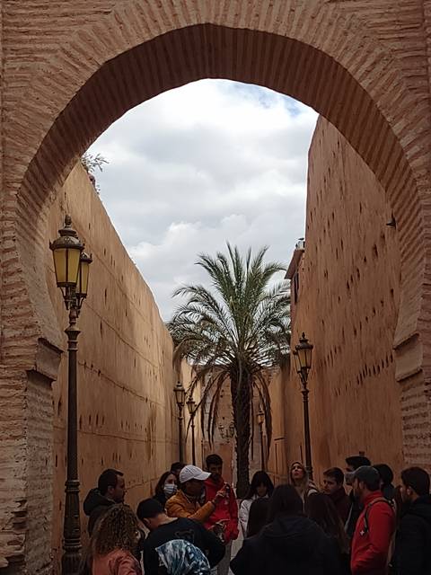       Group of people walking under a large archway.
  