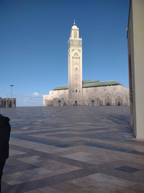 Large mosque with intricate designs and blue sky.