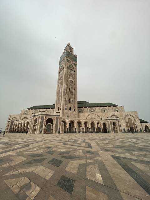 Large mosque with intricate designs and open plaza.