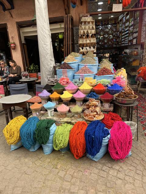 Market stall with piles of colorful spices and textiles.