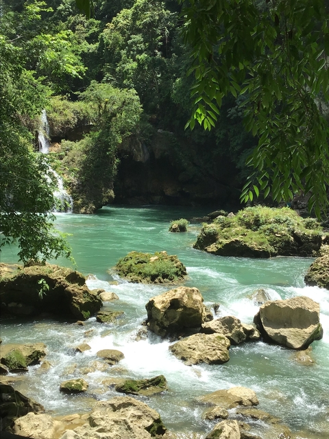       River flowing through rocky landscape with greenery.
  