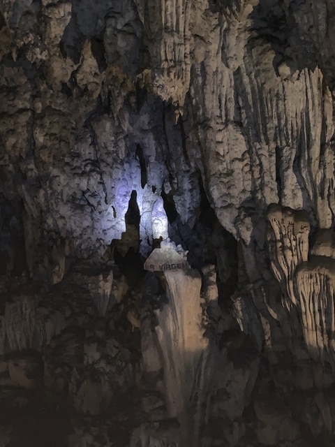       Cave interior with illuminated stalactites and stalagmites.
  