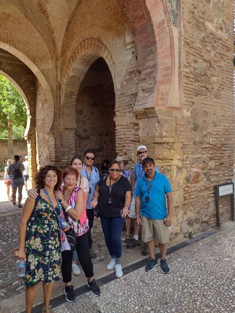 Group posing in front of a historic brick archway.