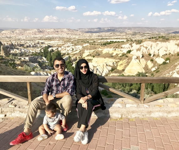 Family sitting and posing with rocky landscape behind.