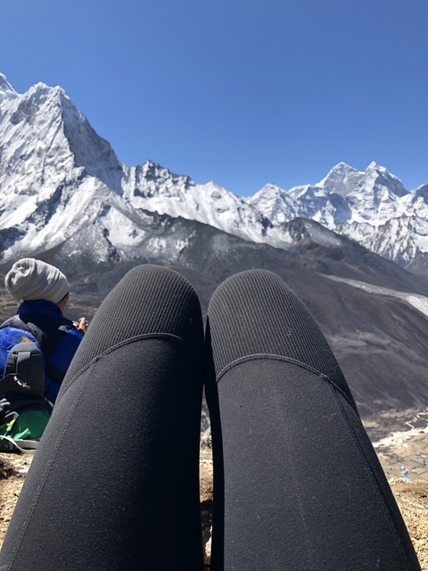 View of a mountainous landscape with snow and a person resting.